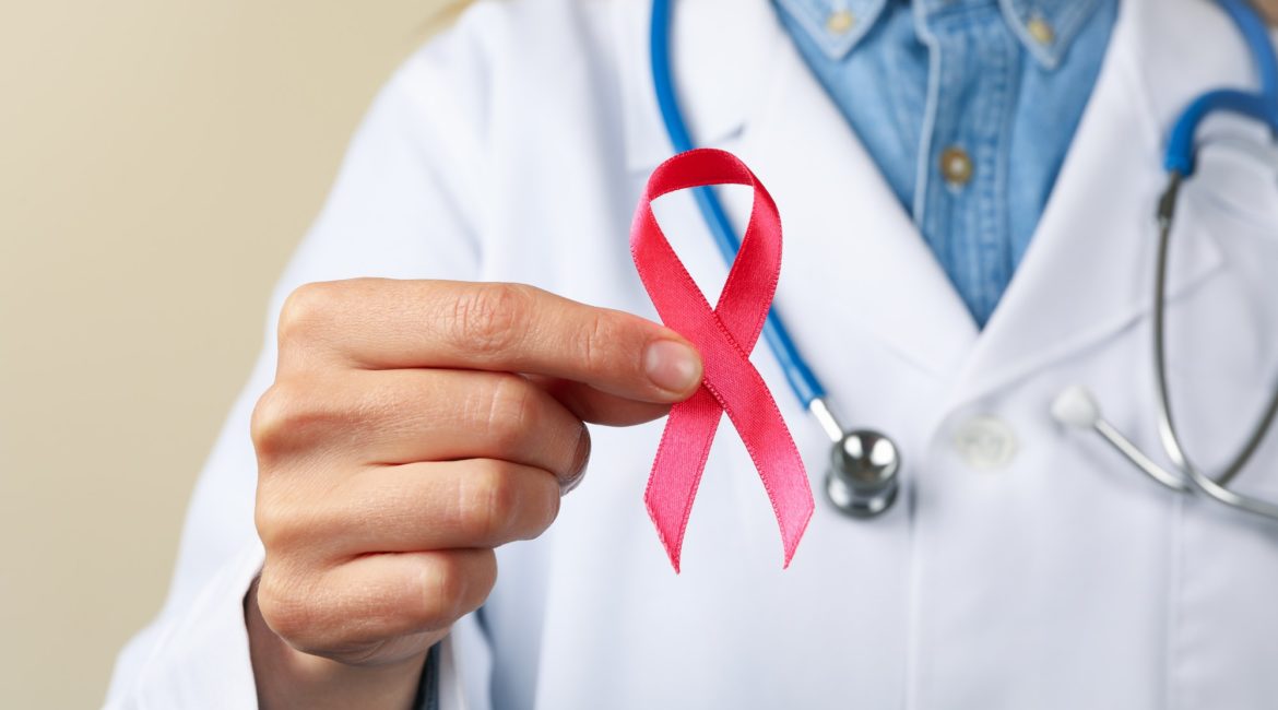 Woman doctor hold pink awareness ribbon, close up